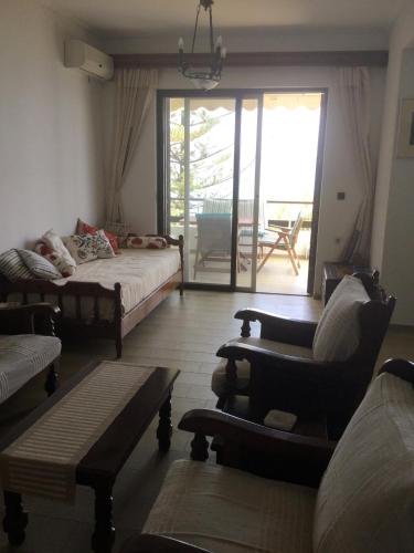 a living room with a bed and a couch and chairs at Lefkada Beachfront Apartment in Nikiana