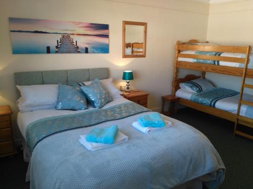 a bedroom with two bunk beds with towels on a bed at 57 New Esplanade Court, Beach Close By Pool View in Paignton