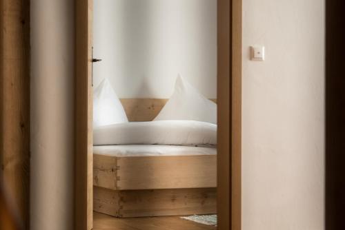 a bedroom with a bed with white sheets and pillows at Alblerhof Oberstdl in Innervillgraten