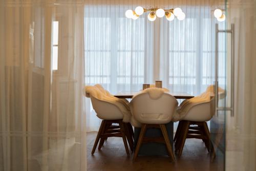 a dining room table with white chairs and a chandelier at Alblerhof Oberstdl in Innervillgraten