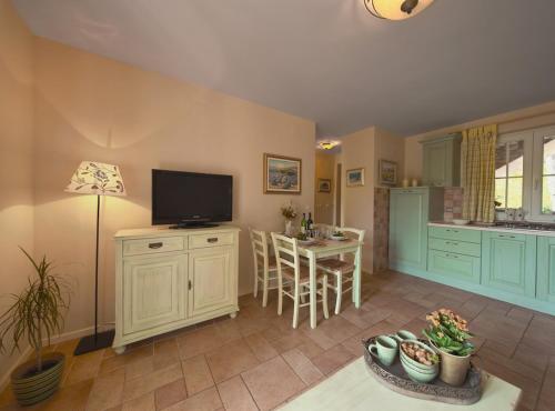 a living room with a television and a kitchen at Villa Rosa in Vrboska