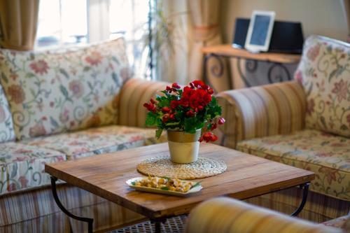 a coffee table with a vase of flowers and food on it at Villa Rosa in Vrboska