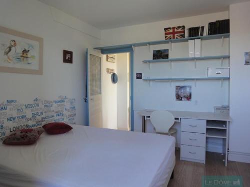 une chambre avec un lit blanc et un bureau dans l'établissement Villa Castelet, à Dinard