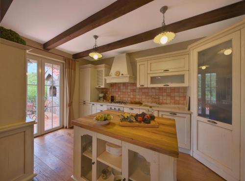 a kitchen with white cabinets and a wooden counter top at Villa Rosa in Vrboska