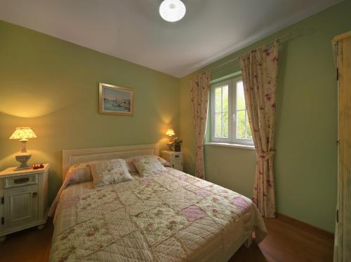 a bedroom with a bed and a window at Villa Rosa in Vrboska