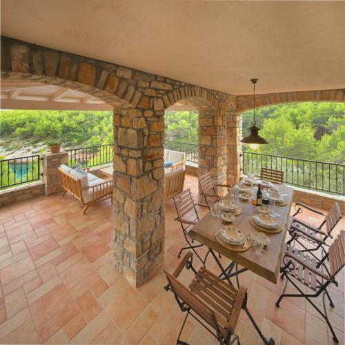 a patio with a table and chairs on a balcony at Villa Rosa in Vrboska