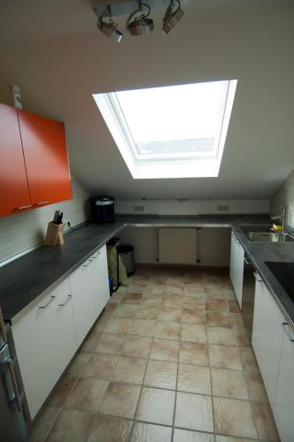 a large kitchen with a skylight in the ceiling at FeWo-Schwarzer in Ingelheim am Rhein