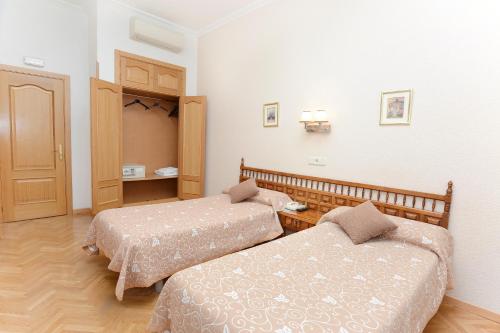 Ένα ή περισσότερα κρεβάτια σε δωμάτιο στο Hostal Biarritz