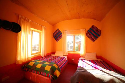 two beds in a room with two windows at Luquina homestay in Puno