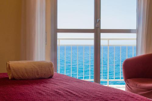 a bedroom with a bed and a large window at Hotel Il Girasole in Bova Marina
