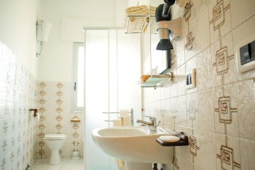 a bathroom with a sink and a toilet at Hotel Il Girasole in Bova Marina