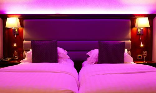 a bedroom with two beds with purple lighting at Crown Spa Hotel Scarborough by Compass Hospitality in Scarborough