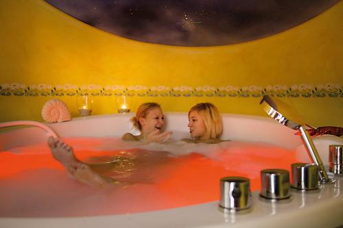 two girls bathing in a bath tub with red water at Forellenhof Rössle Hotel & Restaurant in Honau