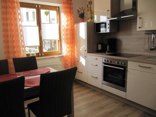 una cucina con tavolo e piano cottura forno superiore di Ferienwohnung Abendstille mit Balkon und TG a Bamberga