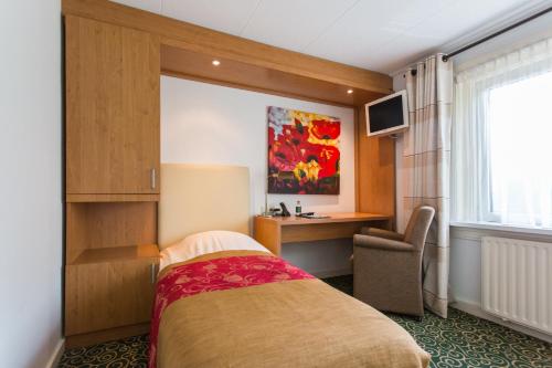 a hotel room with a bed and a desk at Hotel Cafe Restaurant De Gouden Karper in Hummelo