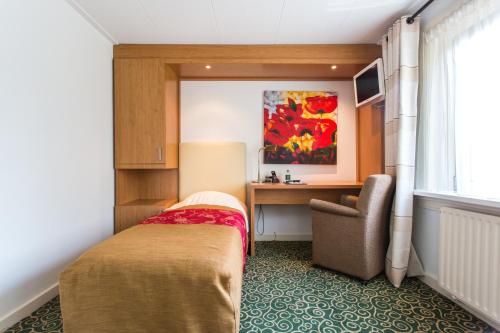 - une chambre avec un lit, un bureau et une chaise dans l'établissement Hotel Cafe Restaurant De Gouden Karper, à Hummelo