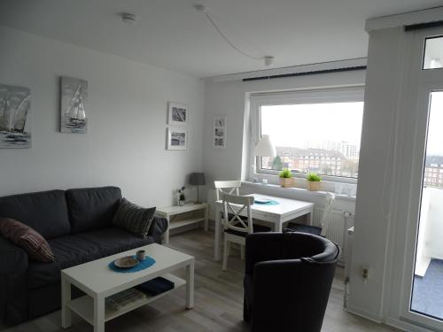 een woonkamer met een bank en een tafel bij Ferienwohnung Jolle in Bremerhaven