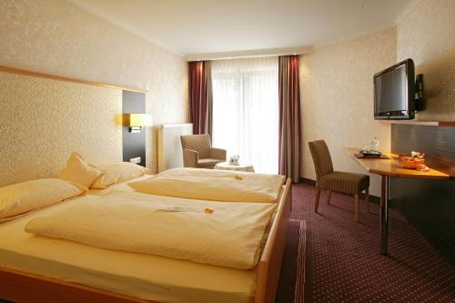 a hotel room with a bed and a desk at Forellenhof Rössle Hotel & Restaurant in Honau