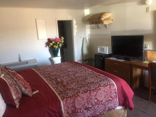 Rustic Motel Rolla في رولا: غرفة فندقية بسرير وتلفزيون بشاشة مسطحة