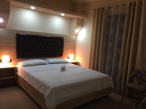 a bedroom with a large bed with two lamps on tables at Guesthouse Liamra in Ulcinj