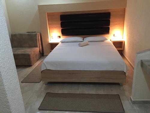 a bedroom with a large bed and a chair at Guesthouse Liamra in Ulcinj