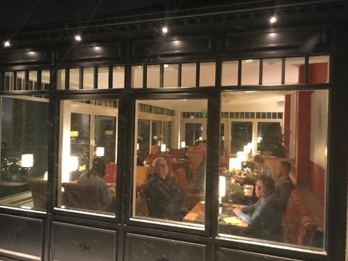 a group of people sitting in a restaurant at Hotel Sonneneck in Zinnowitz