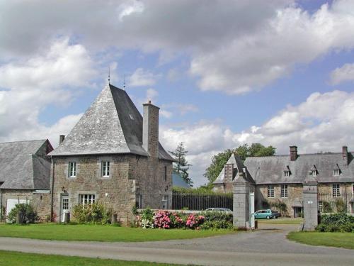 una gran casa de ladrillo con techo gris en Gite Le Saint Anne, en Équilly