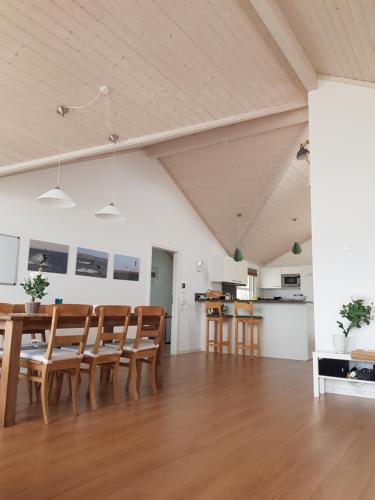 ein Esszimmer und eine Küche mit einem Holztisch und Stühlen in der Unterkunft Ferienhaus Villa Sun Rügen in Vaschvitz