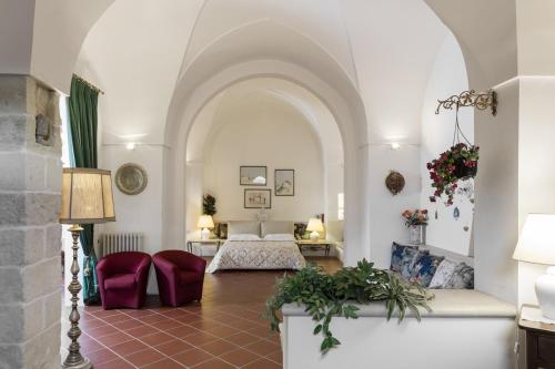 レッチェにあるAntica Villa La Violaのベッドとリビングルームが備わるホテルルームです。