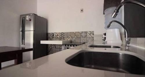 a kitchen with a sink and a refrigerator at Blanc Residence in Pipa