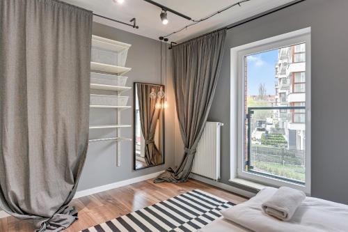 1 dormitorio con cama y ventana grande en Apartament Chmielna 1, en Gdansk