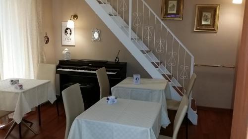 jadalnia z dwoma stołami i pianinem w obiekcie Aparthotel TURNONE w mieście Tarent