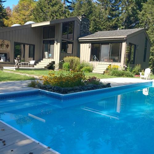 a house with a swimming pool in front of a house at Cricket Hill Lodging in Killington