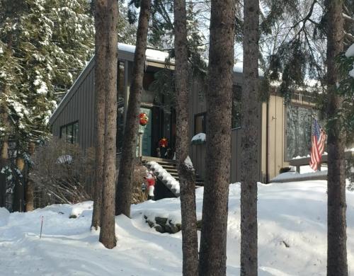 a cabin in the woods in the snow at Cricket Hill Lodging in Killington
