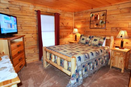 ein Schlafzimmer mit einem Bett und einem TV in einer Hütte in der Unterkunft A Magical Experience in Pigeon Forge