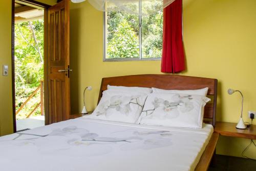 a bedroom with a bed with white sheets and a window at Pousada VillaBahia in Morro de São Paulo