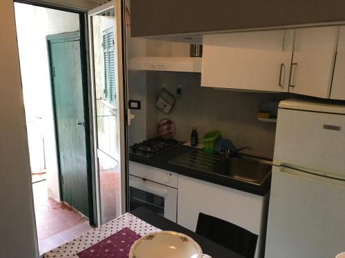 een kleine keuken met een wastafel en een koelkast bij Appartamenti La Quiete in Mele