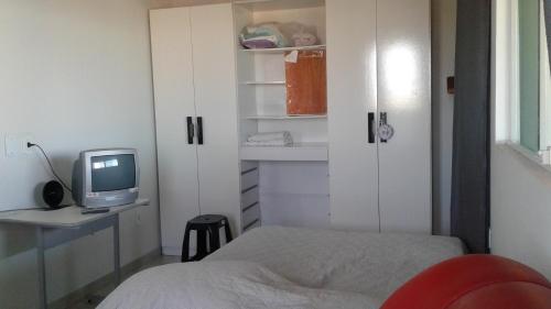 1 dormitorio con 1 cama y escritorio con ordenador en Apt Penedo, en Penedo