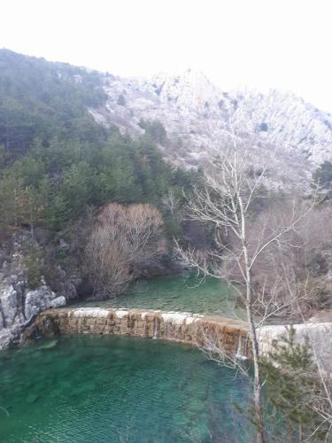 a pool of emerald green water next to a mountain at Apartman Studio Zdravko Eco Village in Imotski