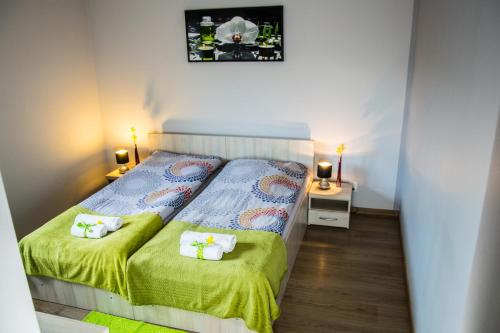 a small bedroom with two beds and two lamps at Pokoje Staromiejski in Uniejow