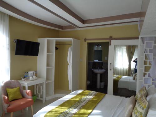 a bedroom with a large bed and a bathroom at The Clarice House in Kisumu