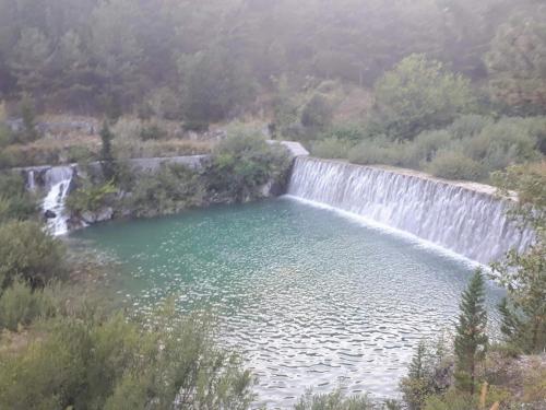 a pool of water next to a waterfall at Apartman Studio Zdravko Eco Village in Imotski