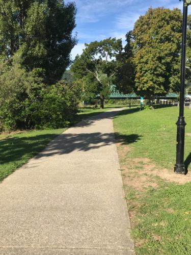 a walking path in a park with a light pole at Riverwalk Apartments in Nelson