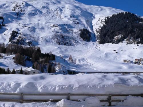 a mountain covered in snow with a train at Pension Hof zur Stilli in Davos
