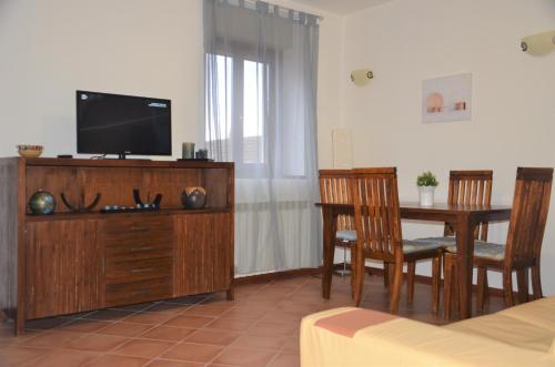 a living room with a tv and a table with chairs at Old Factory in Omegna