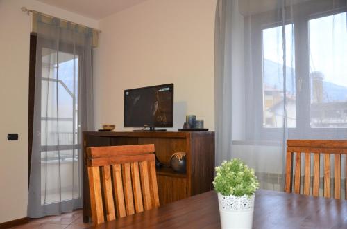 a living room with a television and a table with chairs at Old Factory in Omegna