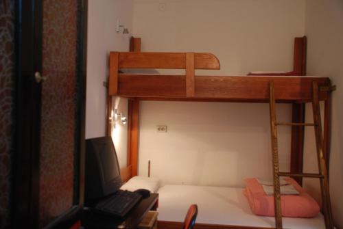 ein Schlafzimmer mit einem Etagenbett und einem Laptop darauf in der Unterkunft Tash Inn Hostel in Belgrad