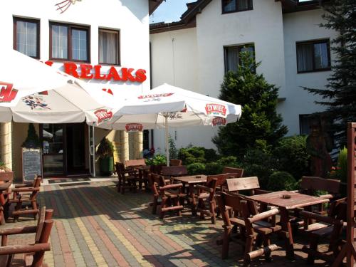 an outdoor restaurant with tables and chairs and umbrellas at Hotel Relaks in Wola Ducka