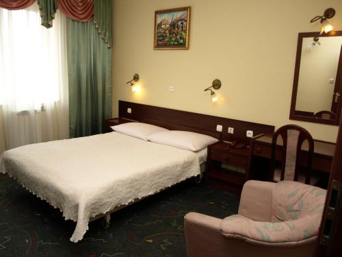 a bedroom with two beds and a chair and a mirror at Hotel Relaks in Wola Ducka
