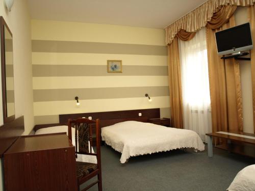 a bedroom with a bed and a flat screen tv at Hotel Relaks in Wola Ducka